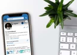 LinkedIn on Mobile next to a keyboard and plant