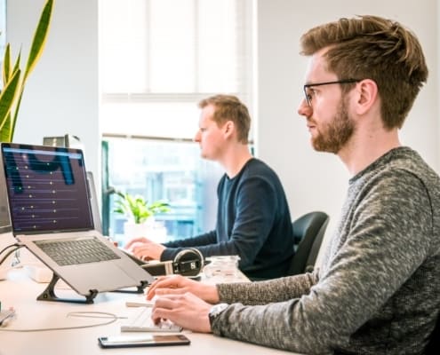 2 male tech workers in an office