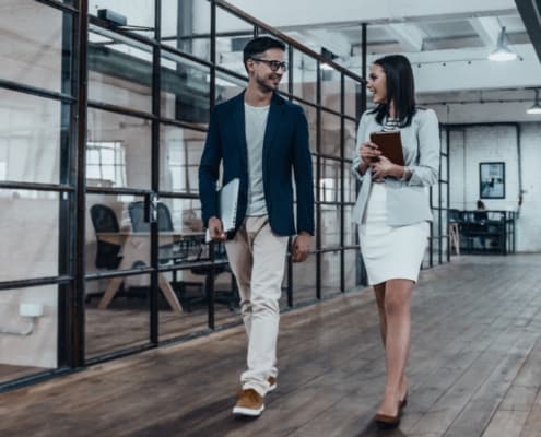 A young professional man and woman walking at work