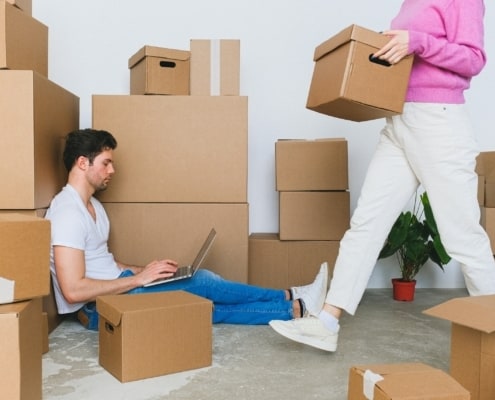 Man working on laptop while moving house